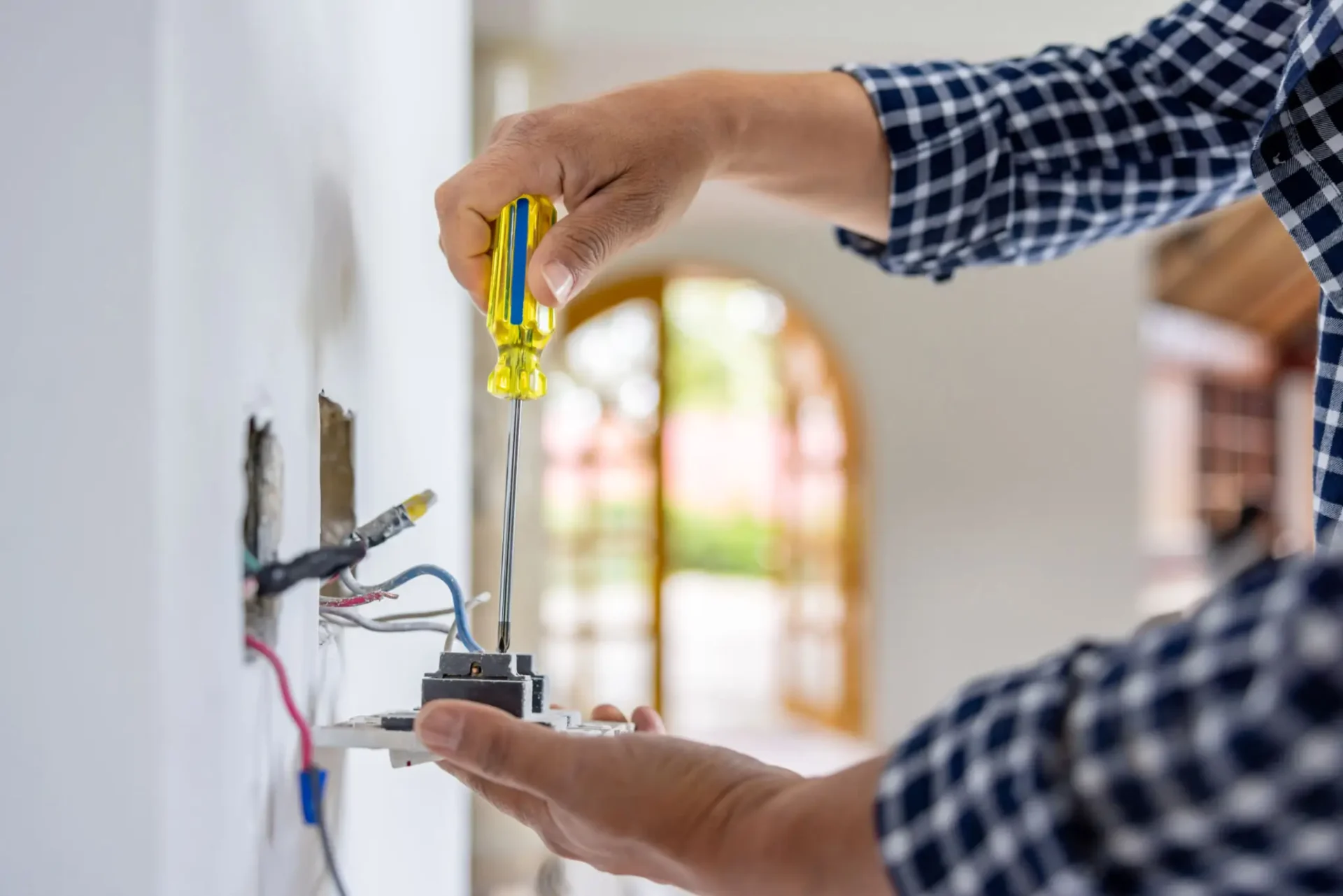 Person fixing electrical wiring using a screwdriver.